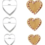 Cortadores de galleta en forma de corazón de diferentes tamaños, con galletas decoradas.