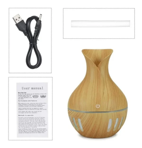 Humidificador difusor de aroma con acabado en madera, incluye manual y cable USB.