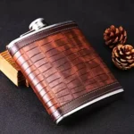 Wiskera de acero inoxidable de 8 oz forrada en cuero marrón texturizado con piñas.