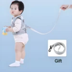 Arnés de aprendizaje para bebé gris con correa ajustable, ideal para primeras caminatas.