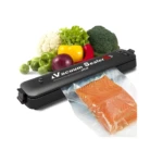 Selladora al vacío de alimentos con filete de salmón y verduras frescas listas para empacar.