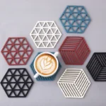 Posa vasos de silicona hexagonales con diseños de rejilla y un café latte.