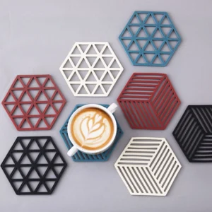 Posa vasos de silicona hexagonales con diseños de rejilla y un café latte.