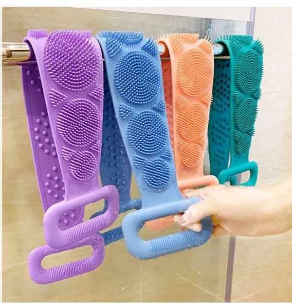 Estropajo de silicona para espalda largo en morado, azul, naranja y verde colgado en barra de ducha.