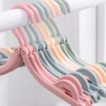 Ganchos plegables de viaje en colores pastel, ideales para espacios pequeños.