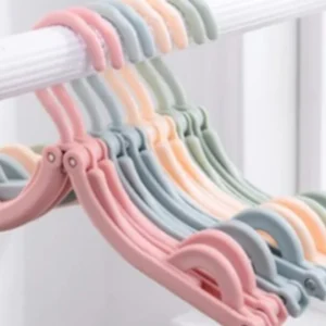 Ganchos plegables de viaje en colores pastel, ideales para espacios pequeños.