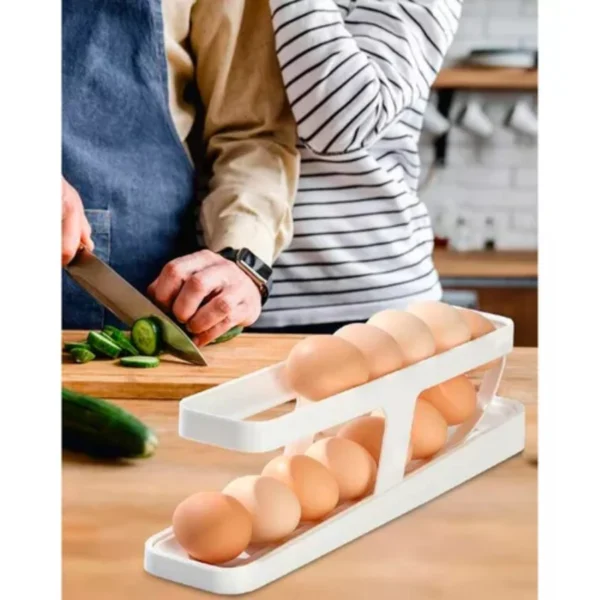 Organizador dispensador de huevos en dos niveles, con persona cortando pepino en el fondo.