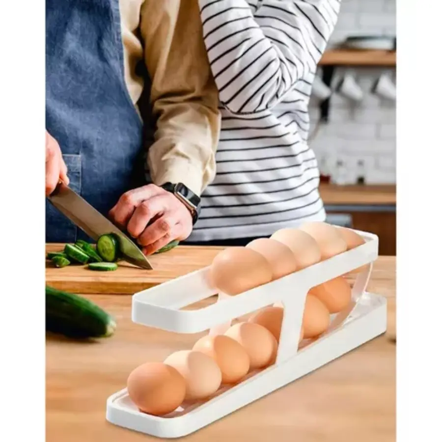 Organizador dispensador de huevos en dos niveles, con persona cortando pepino en el fondo.