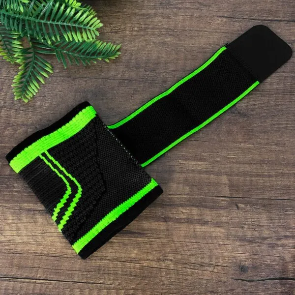 Muñequera de compresión alta negra con detalles verdes, diseño ergonómico para soporte deportivo.