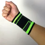 Muñequera de alta compresión negra con detalles en verde neón, vista cercana de la mano cerrada.