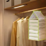 Organizador colgante de 7 puestos en malla verde para ropa y accesorios en closet, visto de frente.