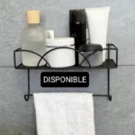 Estante de pared negro con varios artículos de tocador y toalla colgando.
