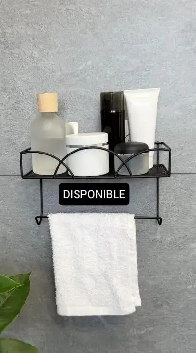 Estante de pared negro con varios artículos de tocador y toalla colgando.
