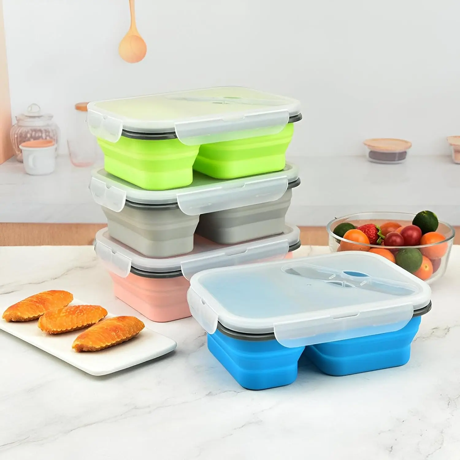 Porta comida plegable azul con compartimentos, ideal para llevar snacks y frutas.