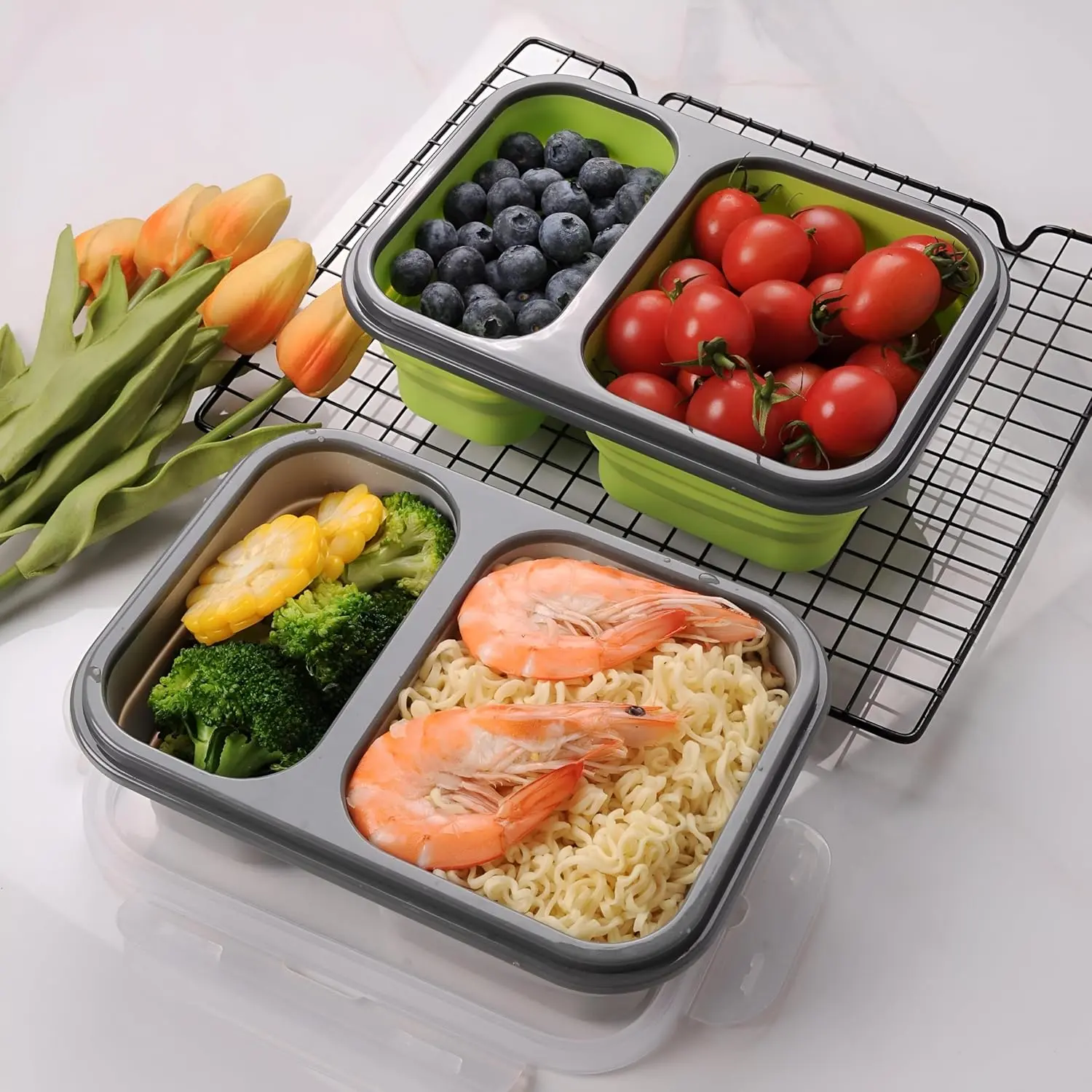 Porta comida plegable con camarones, fideos, brócoli, maíz, arándanos y tomates cherry.