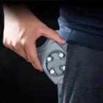 Abrelatas gris colocado en el bolsillo de un pantalón azul oscuro.