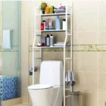 Estantería organizador de baño blanco sobre inodoro, con toallas y productos de higiene.