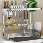 Escurridor de loza 64 cm con secador de platos, cubiertos, utensilios y tabla de cortar sobre el lavaplatos.