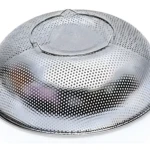 Colador escurridor de 22.5cm en acero inoxidable, con asas y orificios para drenar agua.