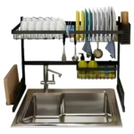 Escurridor de loza de 64 cm negro sobre lavaplatos con platos, cubiertos y accesorios.