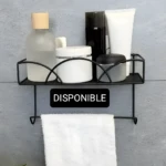 Estante de pared negro con productos de cuidado personal y toalla.