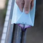 Limpiador de ventanas en acción limpiando guías sucias con paño morado.