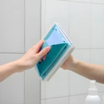 Limpiador de ventanas con mango azul y blanco, ideal para espejos.