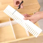 Organizador de rejilla expandible en uso, cortando para ajustar con tijeras en un cajón de madera.
