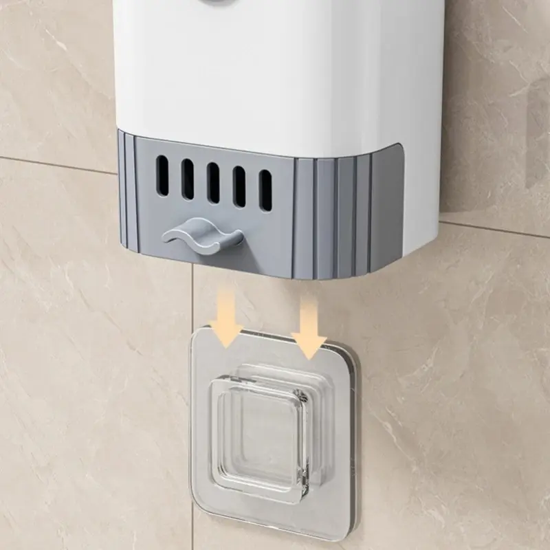 Cepillo de baño blanco y gris colgando en pared con gancho adhesivo transparente.
