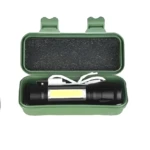 Mini linterna metálica recargable LED en estuche verde con interior de espuma protectora.