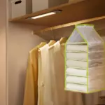 Organizador colgante de 7 niveles para clóset, con ropa doblada.