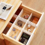 Organizador de escritorio de madera con múltiples compartimentos: bolígrafos, cuadernos, clips, tijeras y calculadora.