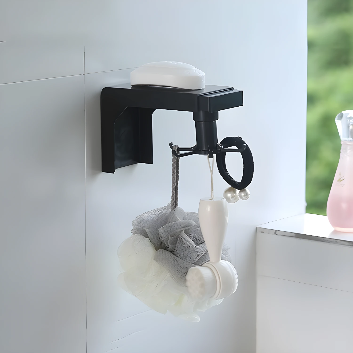 Organizador giratorio negro con jabonera y ganchos para accesorios de baño.