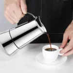 Cafetera italiana de 6 tazas vertiendo café en una taza blanca.