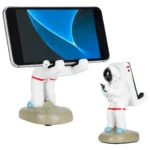 Soporte para celular con forma de astronauta, ideal para decorar tu escritorio.