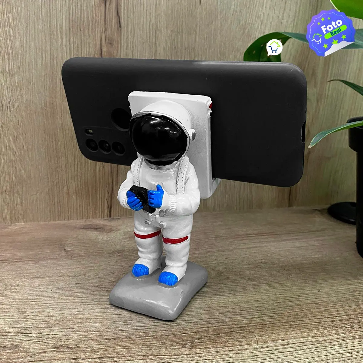 Base celular astronauta Sancafé con celular negro, ideal para escritorio.