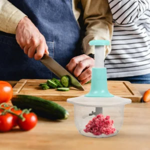 Picador de alimentos manual 2L picando carne molida con verduras en tabla de cortar.