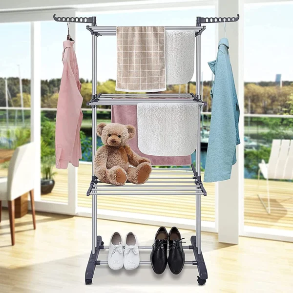 Estante secador de ropa con toallas, oso de peluche y zapatos, ideal para organizar tu hogar.
