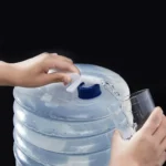 Botellón plegable de agua 5L dispensando líquido en vaso transparente.