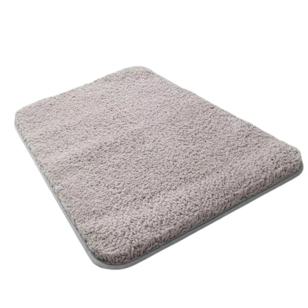 Tapete alfombra absorbente gris con textura suave, detalle de borde.