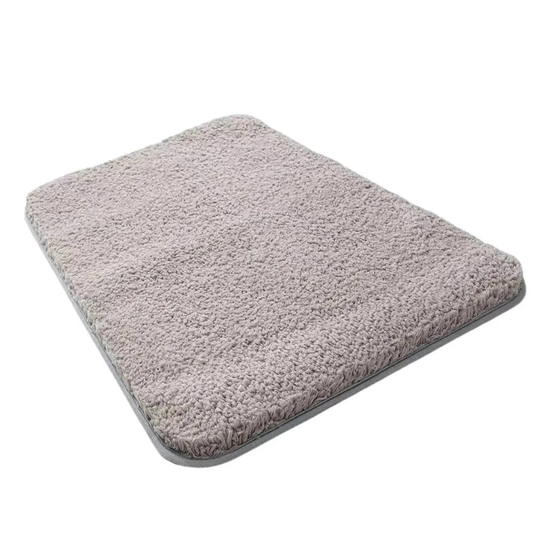 Tapete alfombra absorbente gris con textura suave, detalle de borde.