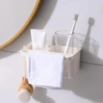 Soporte adhesivo para baño con cepillo facial, toalla y organizador para pasta dental y cepillo de dientes.