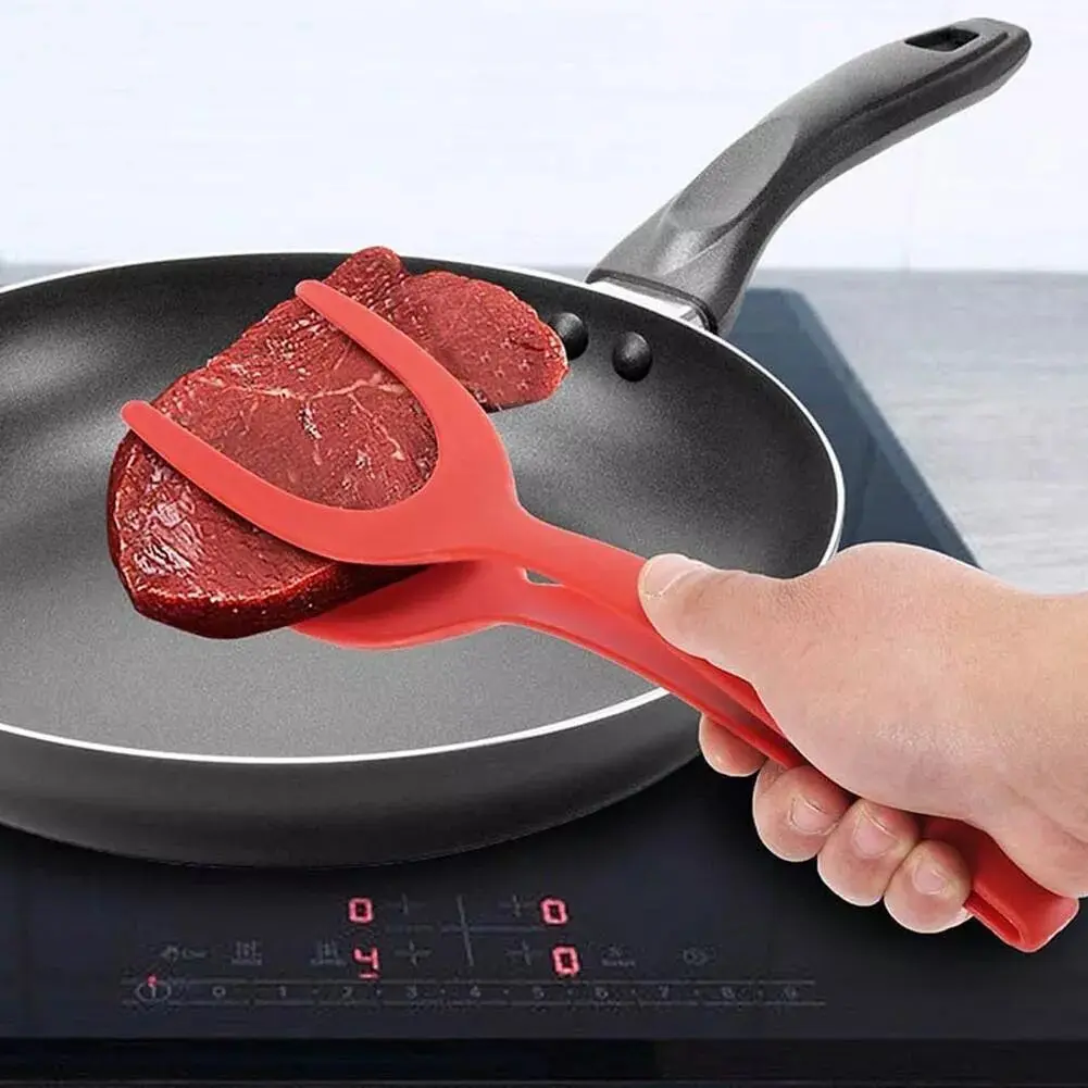 Espátula pinza roja para voltear carne en sartén.