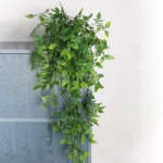 Planta colgante hiedra artificial verde sobre matero gris, decoración colgante.