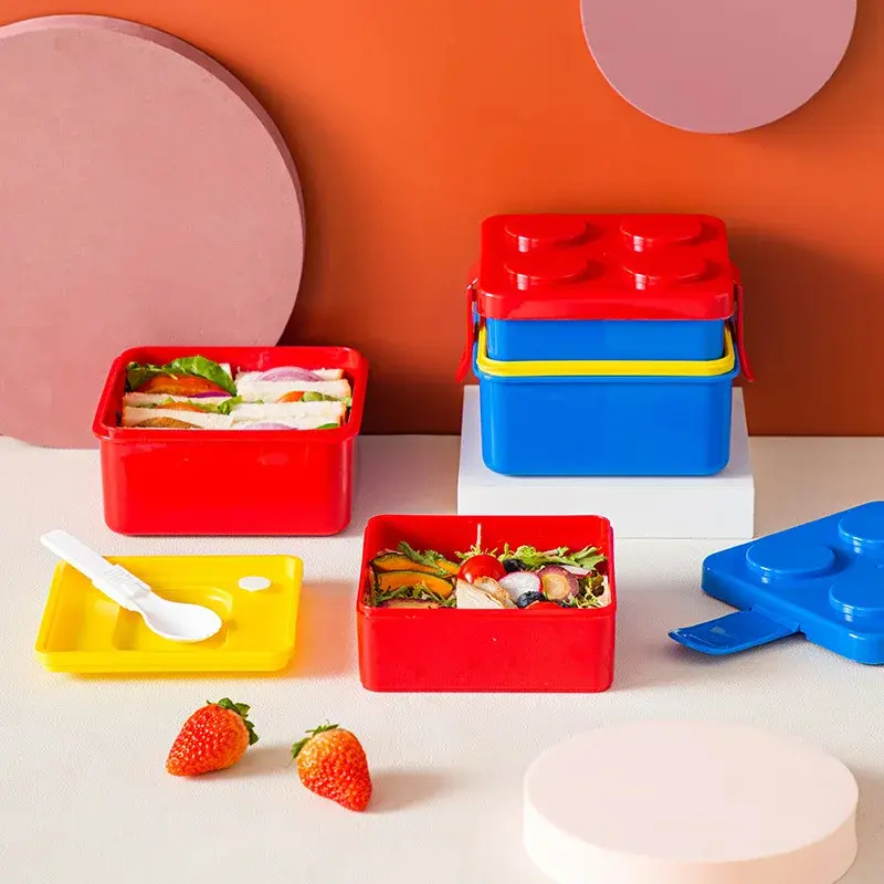 Fiambrera lonchera Lego roja con sándwiches y ensalada, ideal para niños.