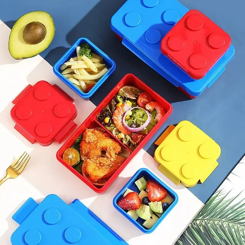 Fiambrera Lonchera Lego con compartimentos, aguacate, ensalada y frutas para almuerzos creativos.