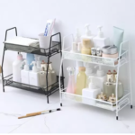 Estante organizador de dos niveles con artículos de tocador y maquillaje en blanco y negro.