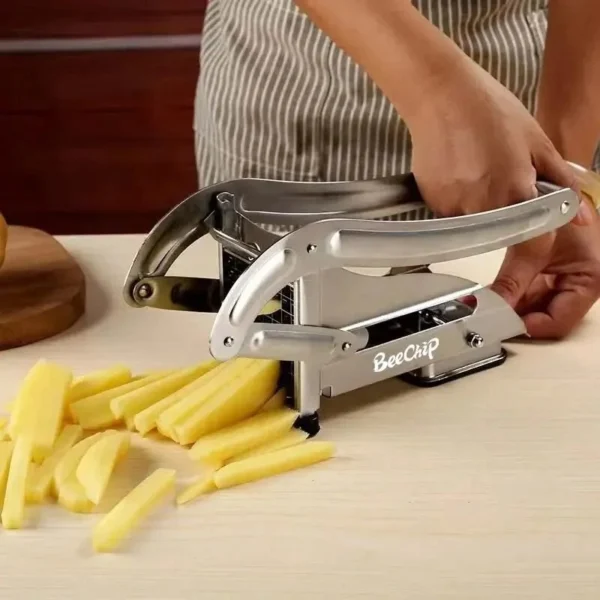Cortador de papas fritas BeeChip picando bastones para freír en una mesa de madera.