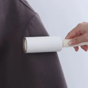 Rodillo quita mota con repuesto sobre tela oscura, ideal para ropa.