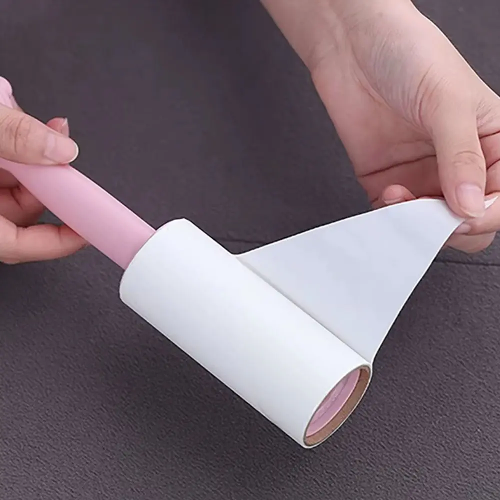 Rodillo quita motas con repuesto blanco en rollo y mango rosado, ideal para limpiar telas.